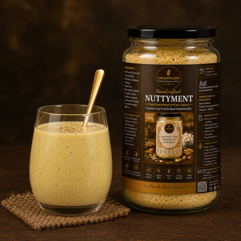 Graindians Homemade Nuttyment – Premium Dry Fruit & Seed Nutrition Mix in a glass jar with a glass of milk, made with makhana, almonds, cashews, walnuts, pistachios and nutritious seeds.